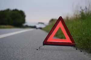 warning triangle, behind it a white car with a breakdown photo
