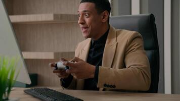 African American man worker funny businessman gamer play online game with joystick playing console football match on computer gaming addict employee manager ceo executive having fun in office video