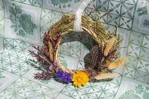 Handcrafted wreath showcasing unique dried flowers and herbal elements, perfect decoration for home or festive occasions, adding charm and warmth to any space photo