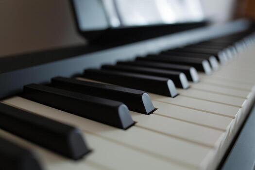 Close-up of digital piano keys with soft lighting. A shallow depth of field emphasizes the black and white keys, creating a calm, artistic mood. Music sheets are blurred in the background. photo