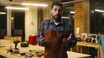 Confused Caucasian wood master man shrugging shoulders doubt gesture in workshop small business male artist designer incertitude woodworker craftsman hesitate guy uncertain feedback difficult question video
