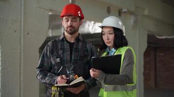Asian female engineer Caucasian male worker handshake site inspection discussion construction teamwork partnership safety planning shake hands cooperation industrial progress multiethnic collaboration video