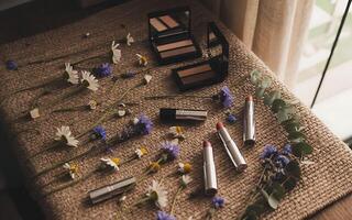 Makeup products on a table with flowers photo