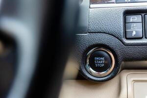 Close up image of start and stop engine botton on car. photo
