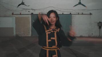 Two dancers performing in an industrial space, showcasing dynamic movements and expressive choreography. One dancer is in a black outfit with gold accents video
