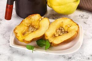 A white plate topped with a half of a yellow pear photo