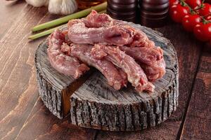 A wooden table with a bunch of raw meat on it photo