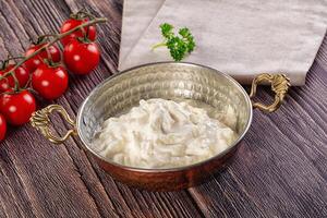 A bowl of yogurt with tomatoes and herbs photo