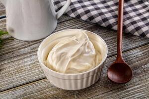 Yogurt in a bowl with a wooden spoon photo