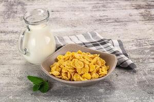 Corn flakes and milk on a wooden table - stock photo - images