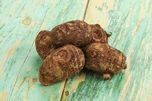 A pile of brown nuts on a green wooden table photo