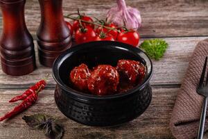A bowl of meatballs with a knife and fork photo