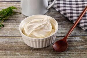 Yogurt in a cup and spoon on a wooden table photo
