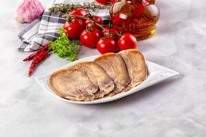 A plate of meat with tomatoes and herbs on a table photo