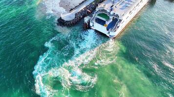 Aerial view of a ferry docking at Queenscliff terminal, showcasing vibrant turquoise waters and dynamic wave patterns video