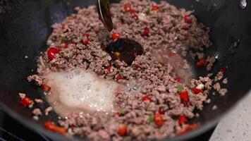 Beef stir-fry preparation in a kitchen with sauce addition, vibrant ingredients, and dynamic cooking process video