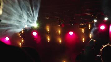 Crowd enjoying concert with bright lights and smoke on stage video