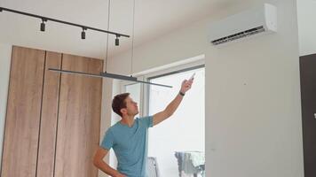 Man Adjusting Air Conditioner Temperature With Remote Control video