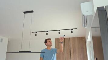 Man Adjusting Air Conditioner Temperature With Remote Control at Home video