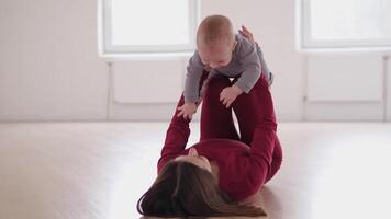 A mother joyfully interacts and plays with her baby in a bright, spacious, and colorful room filled with warmth video