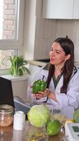 A nutritionist conducts an online session with patients at a table with a variety of fruits and vegetables. Healthy eating improves metabolism and overall health. Health concept, fitness. video
