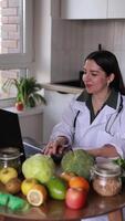 A nutritionist communicates online with patients at a table with fruits and vegetables. Fresh products strengthen the immune system and improve health. Health and nutrition concept, clinic, wellness. video