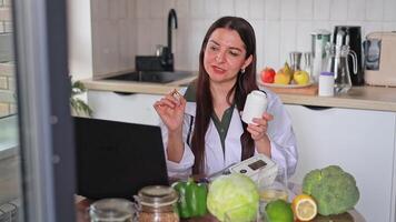 A nutritionist is conducting an online consultation with patients and showing a jar of pills. Vitamins improve immunity and overall health. Health concept, clinic, wellness. video