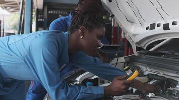 EV car check, diverse mechanic coworker inspects and maintains service of electric engine and battery in fixed automobile garage station, professional technology transportation industry business. video