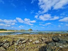 Coastal Landscape with Rocks and Blue Sky at Tropical Beach photo