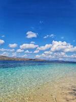 Crystal Clear Ocean Water and Blue Sky with Clouds at Beach photo