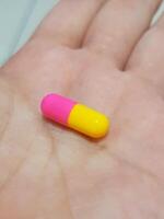 Holding Colorful Capsule in Hand Close-up for Healthcare photo