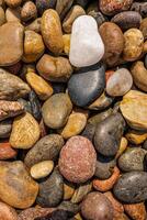 Relaxing colorful pebbles rounded rocks top view natural texture forming organic pattern serene background zen mood beach stones meditation surface earthy tones tranquil calm inspiration wallpaper photo