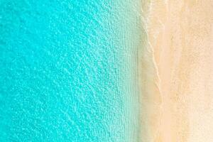 Aerial top view of empty Caribbean beach with yellow sand and clear turquoise water, peaceful tropical shoreline for summer vacation, nature background and travel destination photo