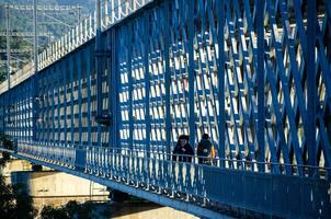 two pilgrims to Santiago de Compostela crossing the international bridge over the river Minho between Tui and Valenca do Minho from Portugal photo