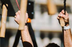 an athlete's powerful hands tackling a monkey bar or peg board obstacle photo