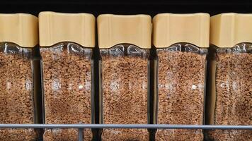 Glass jars of instant coffee filling a supermarket shelf photo