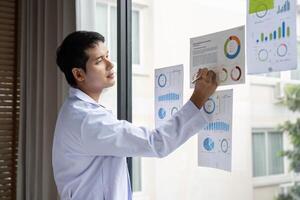 Doctor writing insights from data analysis on report at hospital photo