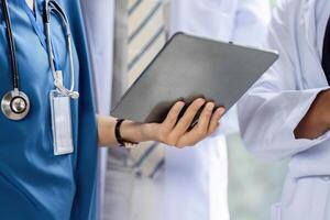 Doctor using tablet to access patient records during consultation photo