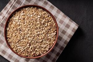 Rolled Oats in Ceramic Bowl on Brown Checkered Napkin Top View photo