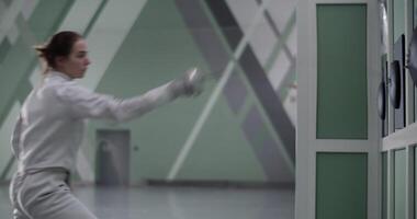 Female fencer practicing strikes in gym video