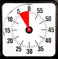 A red and white clock with a black background photo