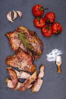 Grilled pork chops with tomatoes and herbs on a slate background photo