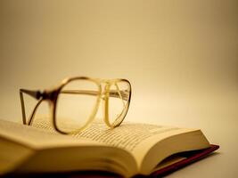 A pair of glasses resting on top of an open book photo