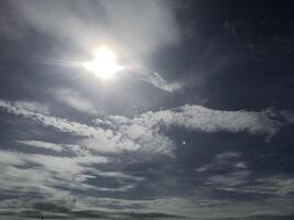 A person on a beach with a kite flying in the sky photo