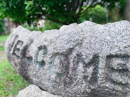 Welcome sign on a rock in the park photo