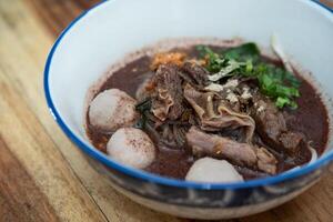 A bowl of meat and noodles with vegetables photo