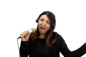 A woman with headphones on singing into a microphone photo