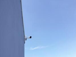 A camera is mounted on the side of a building photo