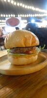 A hamburger on a wooden plate photo