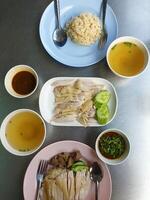 A table with four plates of food and bowls of soup photo